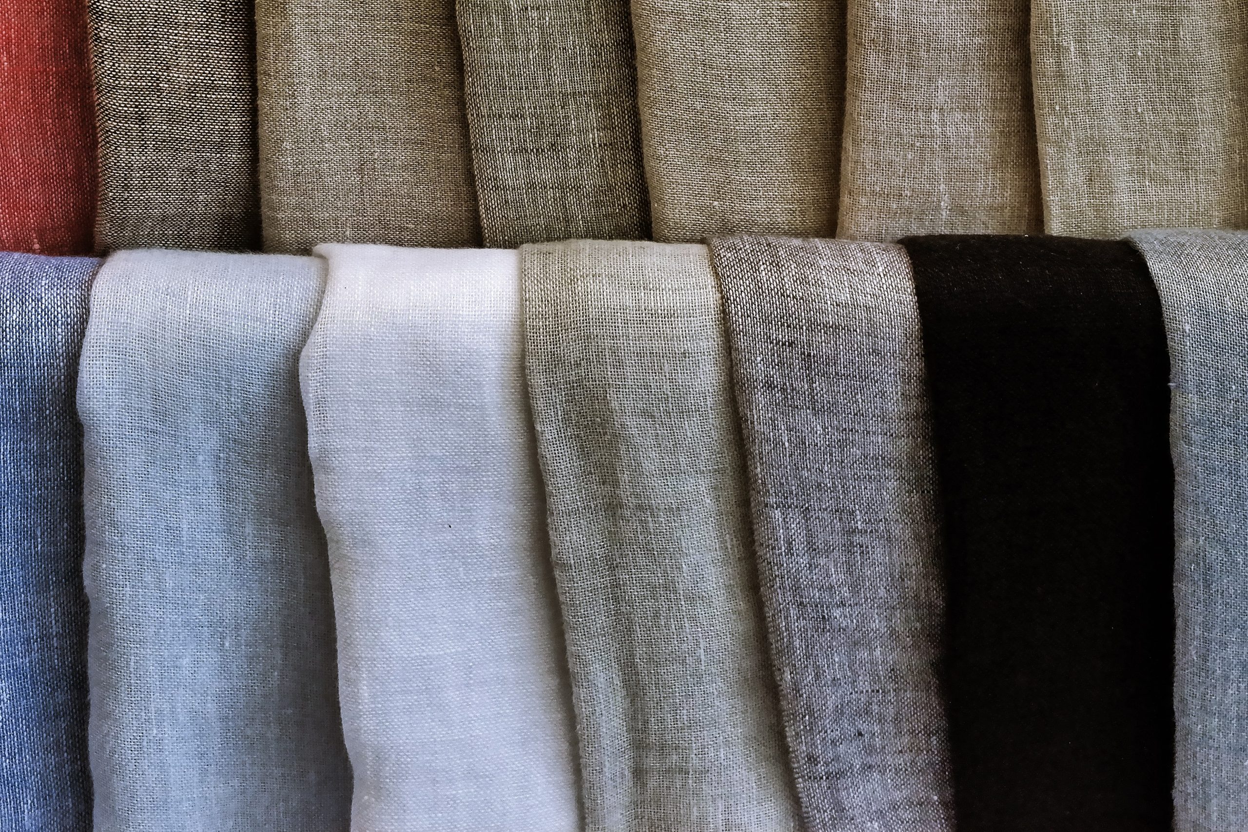 Different pieces of linen folded nicely across a few racks