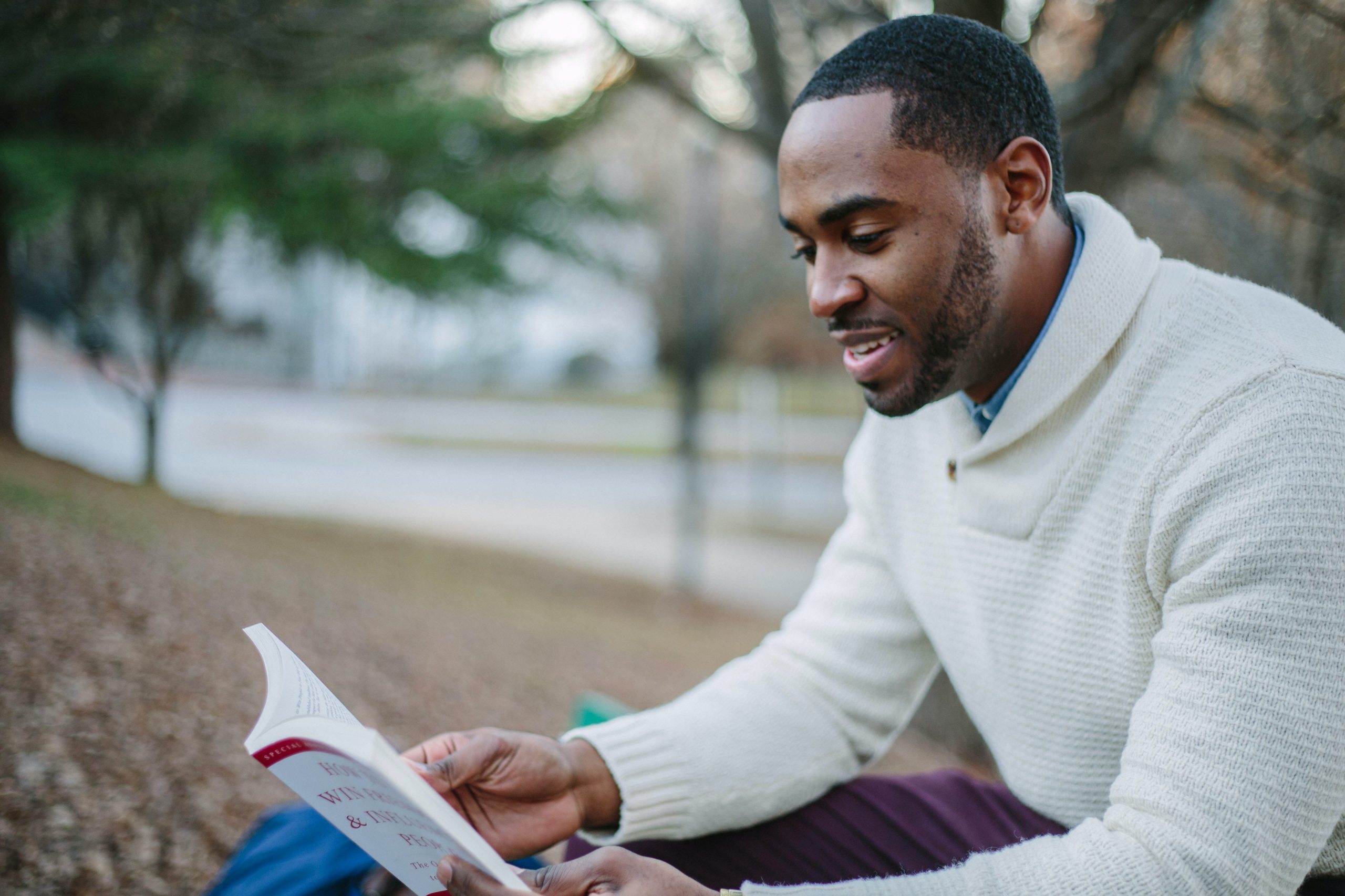 Man reading a book at the park