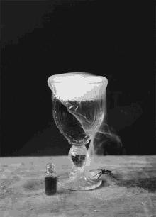 Potion with smoke coming out of the top in a black and white setting