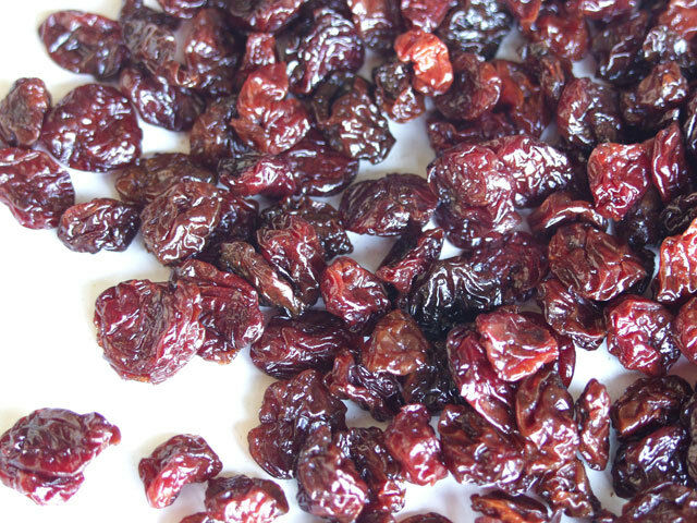 Dried Tart cherries scattered across a white flat surface