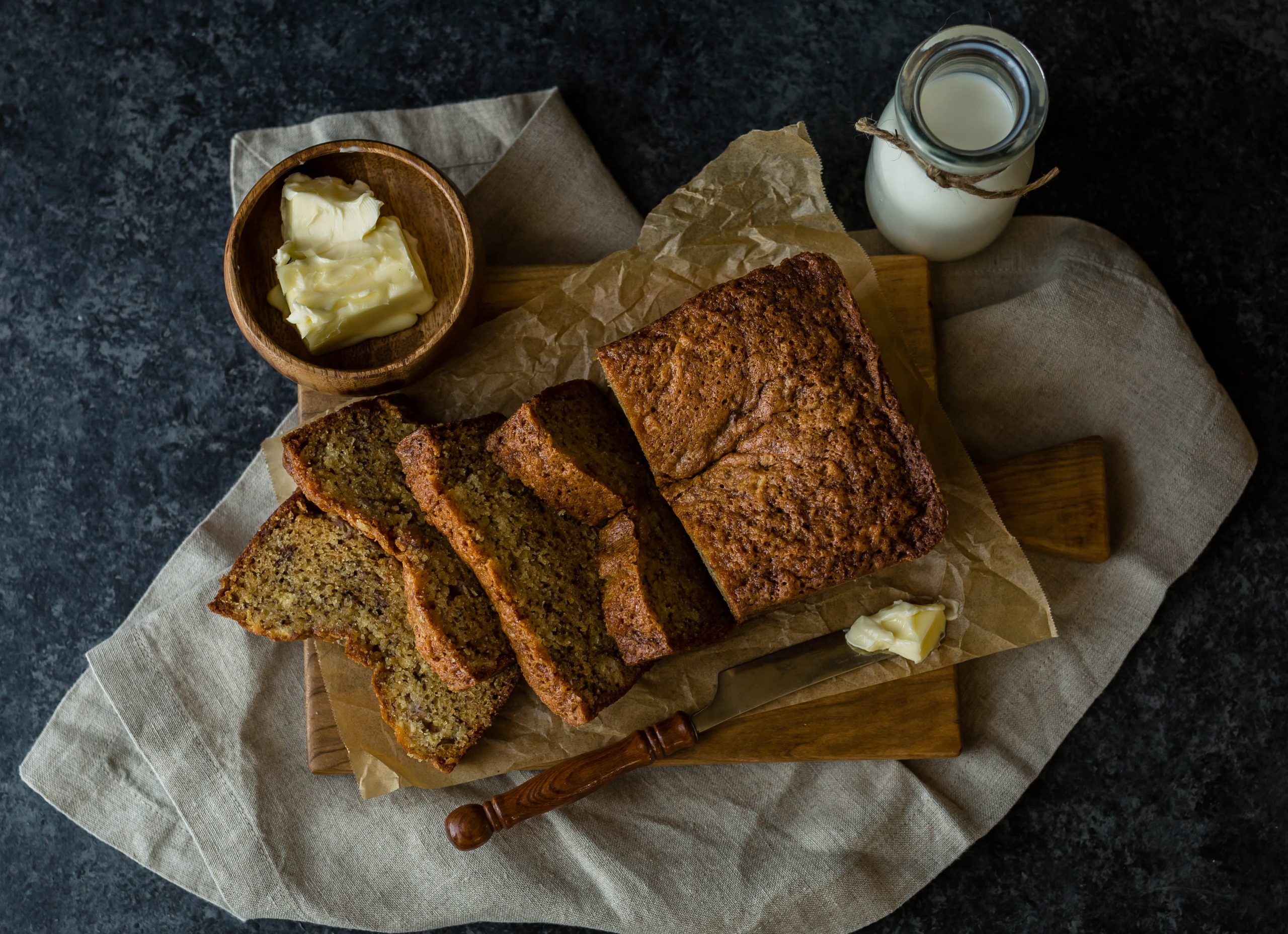 Banana Bread sliced up all pretty on a wooden table